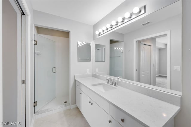 bathroom featuring vanity, tile patterned flooring, and a shower with door