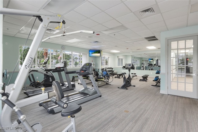 gym with light carpet and a paneled ceiling