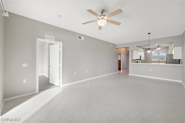 unfurnished living room with ceiling fan and light tile patterned floors