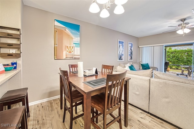 dining space featuring light hardwood / wood-style floors and ceiling fan with notable chandelier