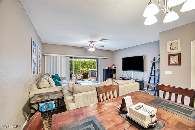 living room with ceiling fan with notable chandelier