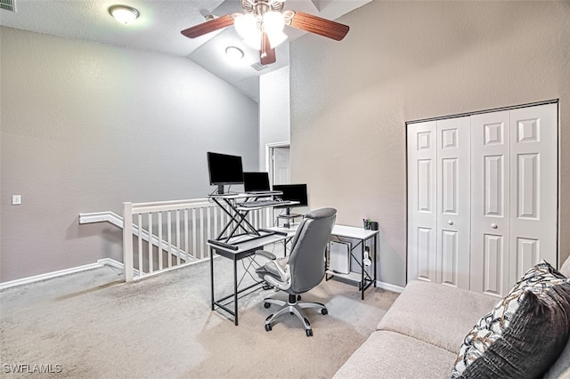 carpeted office featuring lofted ceiling, ceiling fan, and a textured ceiling