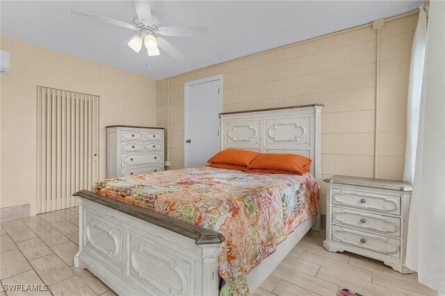 bedroom with a wall mounted air conditioner and ceiling fan