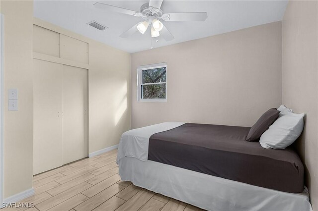 bedroom featuring ceiling fan, a closet, and light hardwood / wood-style floors