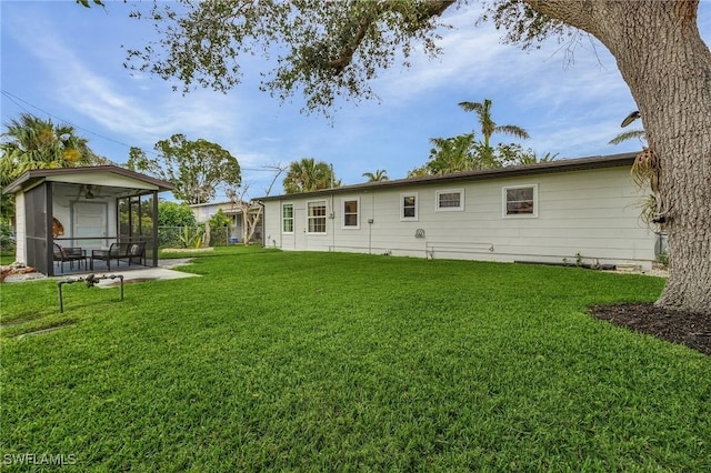 rear view of property featuring a sunroom and a yard