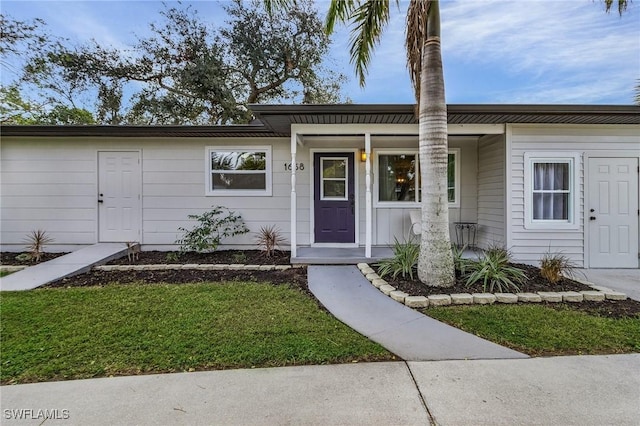 view of front of house featuring covered porch and a front yard