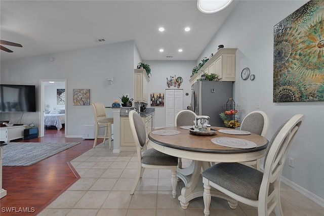 tiled dining space featuring vaulted ceiling and ceiling fan