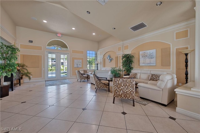 living room featuring a towering ceiling, light tile patterned flooring, and french doors