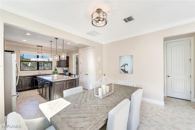 tiled dining area featuring ornamental molding and sink