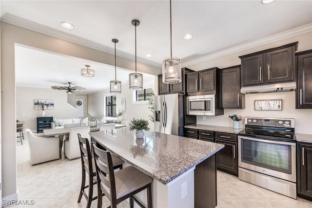 kitchen with pendant lighting, stainless steel appliances, stone counters, ceiling fan, and dark brown cabinets