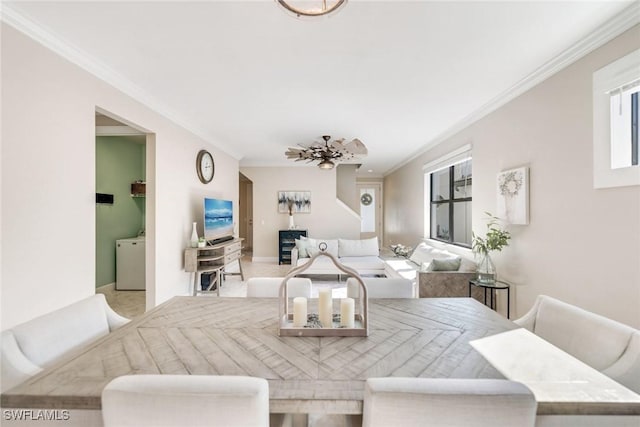 dining space featuring ceiling fan, ornamental molding, and light carpet