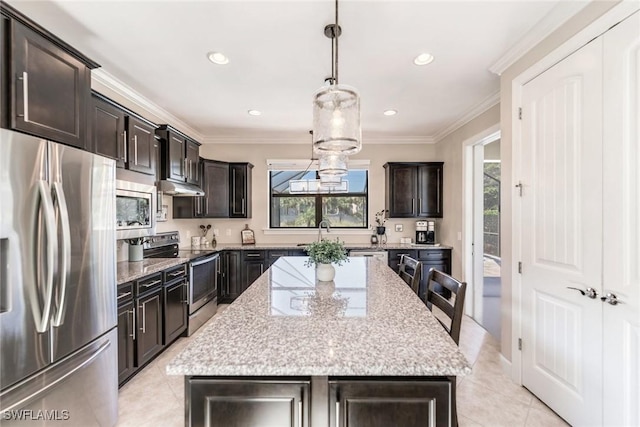 kitchen with stainless steel appliances, hanging light fixtures, a center island, light stone countertops, and light tile patterned flooring