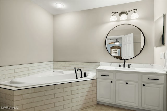 bathroom with tiled tub, tile patterned flooring, and vanity