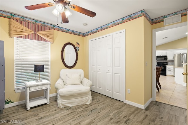 sitting room with ceiling fan and light hardwood / wood-style flooring