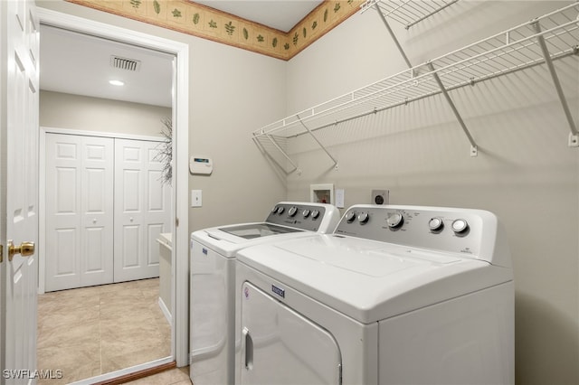 laundry area with washer and clothes dryer and light tile patterned flooring