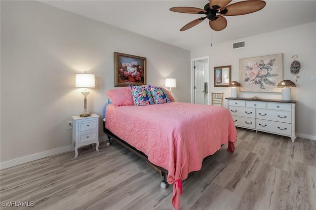 bedroom with baseboards, ceiling fan, wood finished floors, and visible vents