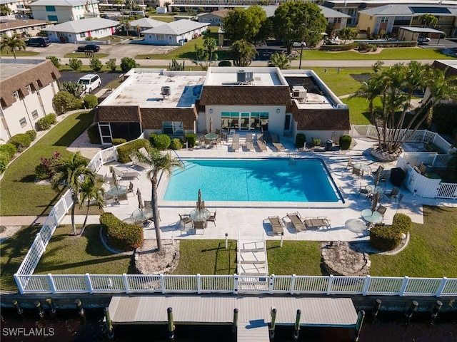pool with a patio area, fence, and a residential view