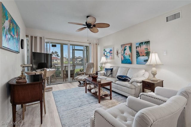 living room with ceiling fan, wood finished floors, and visible vents