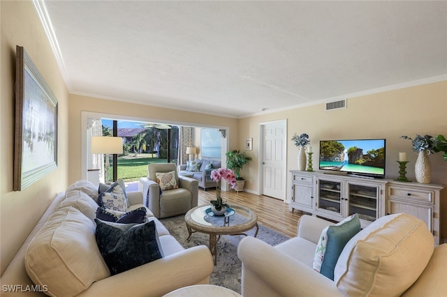 living room with light wood-type flooring and crown molding