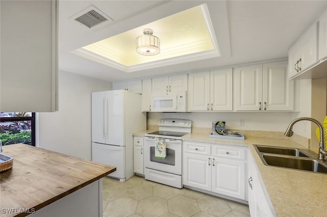 kitchen featuring white cabinetry, white appliances, sink, and a tray ceiling