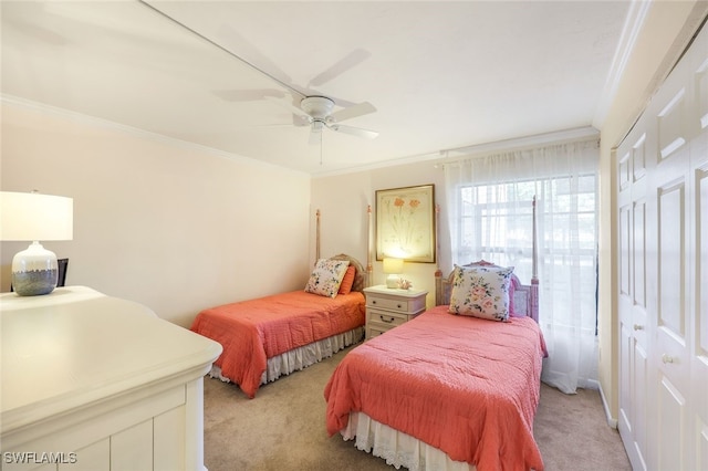 carpeted bedroom with ceiling fan, a closet, and ornamental molding