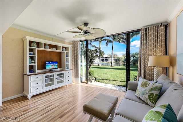 living room with ceiling fan, expansive windows, light hardwood / wood-style floors, and crown molding