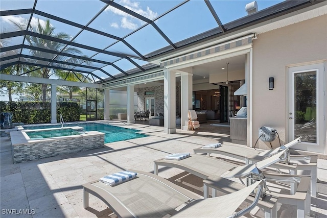 view of swimming pool with an in ground hot tub, glass enclosure, and a patio area