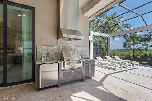 view of patio featuring a lanai, a grill, sink, and exterior kitchen