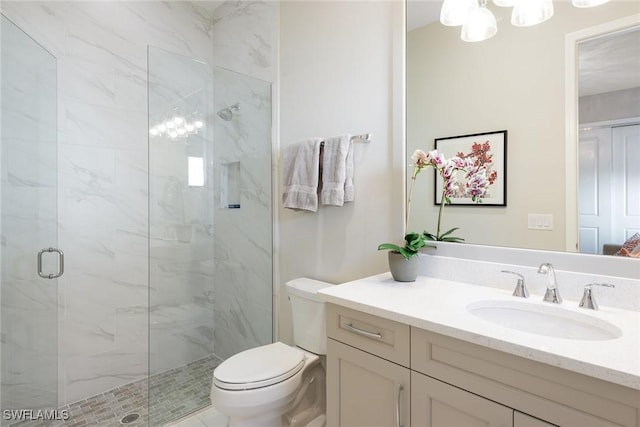 bathroom with vanity, toilet, and a shower with door