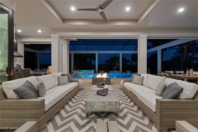 living room with ceiling fan and a raised ceiling