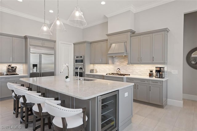 kitchen featuring a kitchen island with sink, premium range hood, beverage cooler, and tasteful backsplash