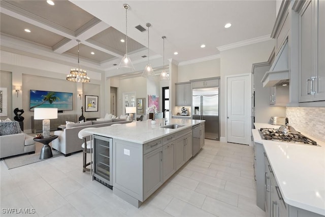 kitchen featuring a large island, sink, stainless steel built in refrigerator, and coffered ceiling