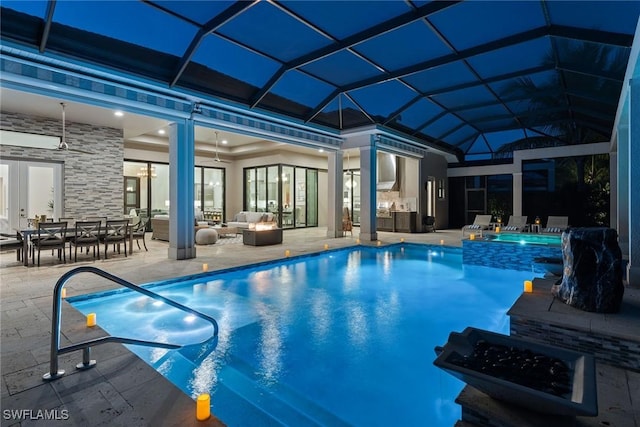 view of pool with glass enclosure, an outdoor living space, and a patio