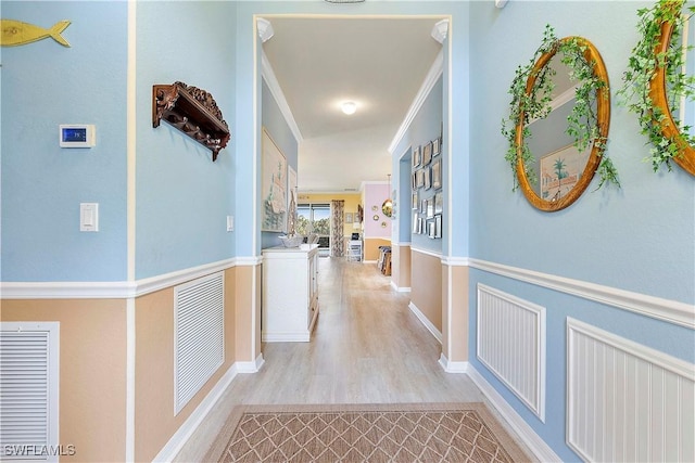 hallway featuring light hardwood / wood-style floors and crown molding