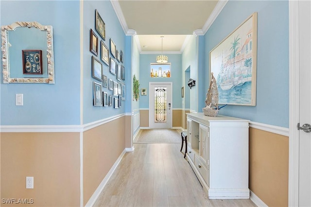 doorway featuring light wood-type flooring and crown molding