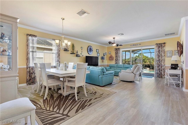 dining area featuring ceiling fan with notable chandelier, light hardwood / wood-style flooring, and ornamental molding