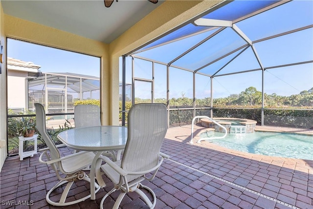 exterior space with a lanai, a patio area, an in ground hot tub, and pool water feature