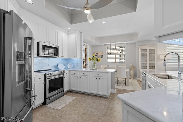 kitchen featuring white cabinets, a raised ceiling, sink, and appliances with stainless steel finishes