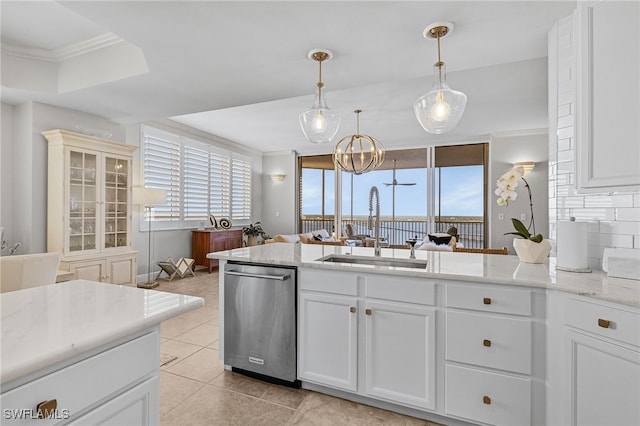 kitchen featuring light stone counters, stainless steel dishwasher, ornamental molding, sink, and pendant lighting