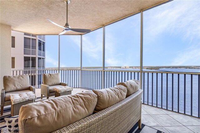 sunroom / solarium featuring a water view and ceiling fan