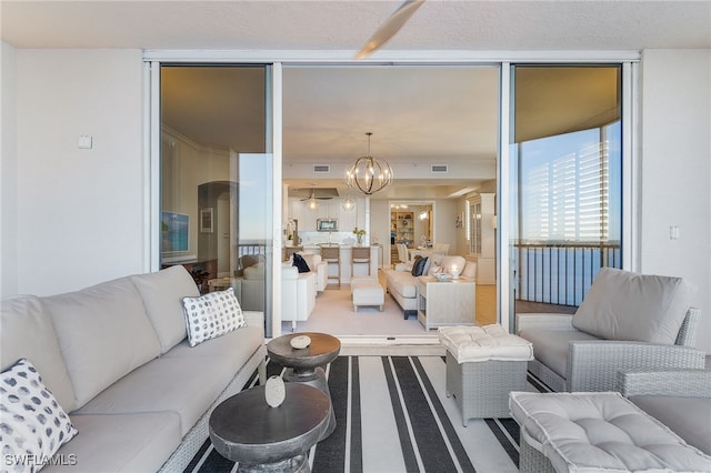 carpeted living room featuring an inviting chandelier