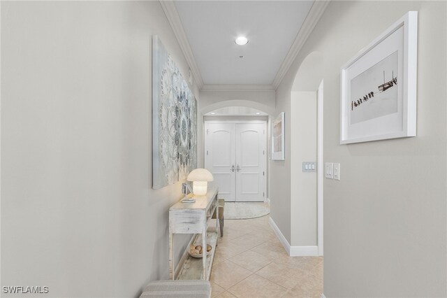 hallway featuring light tile patterned flooring and ornamental molding