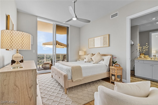 bedroom with access to exterior, ensuite bath, ceiling fan, sink, and light hardwood / wood-style floors