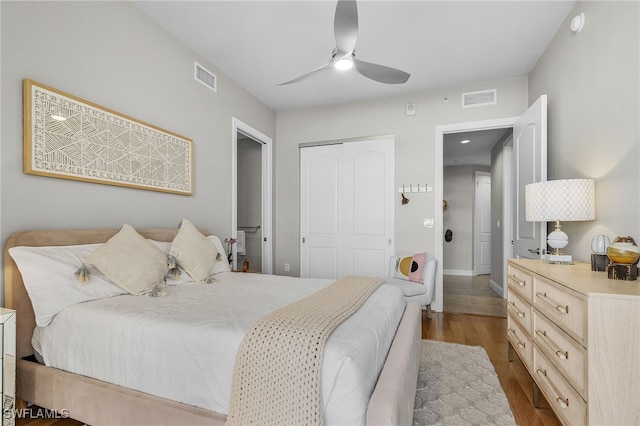 bedroom with ceiling fan, wood-type flooring, and a closet