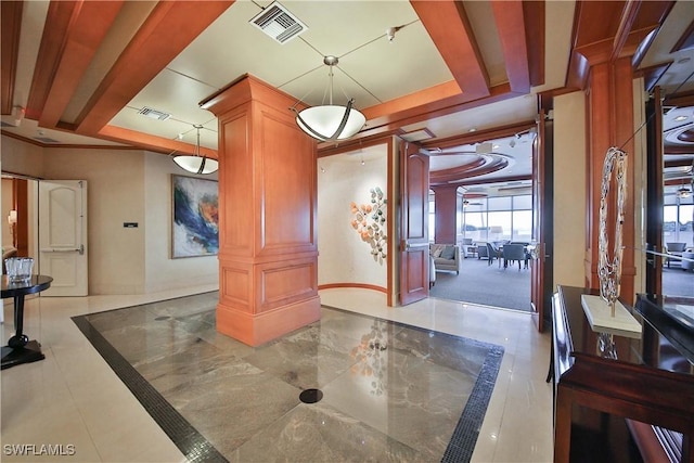 interior space featuring a tray ceiling and decorative columns