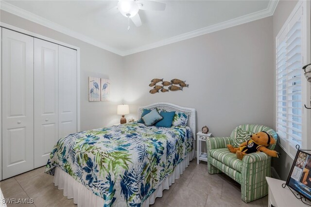 bedroom featuring ornamental molding, a closet, light tile patterned floors, and a ceiling fan