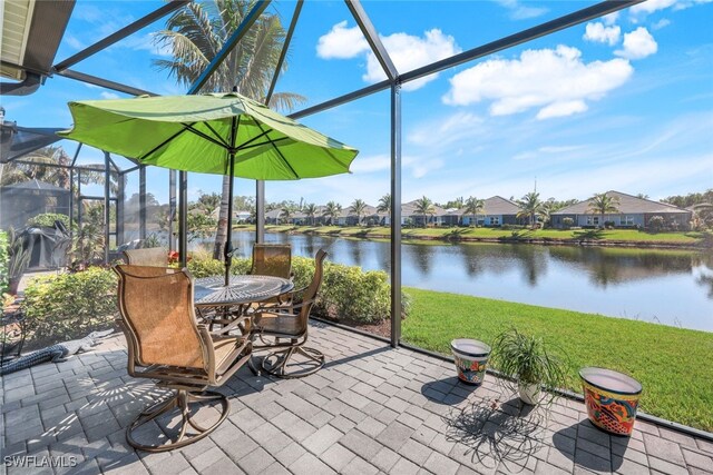 view of patio featuring a lanai and a water view