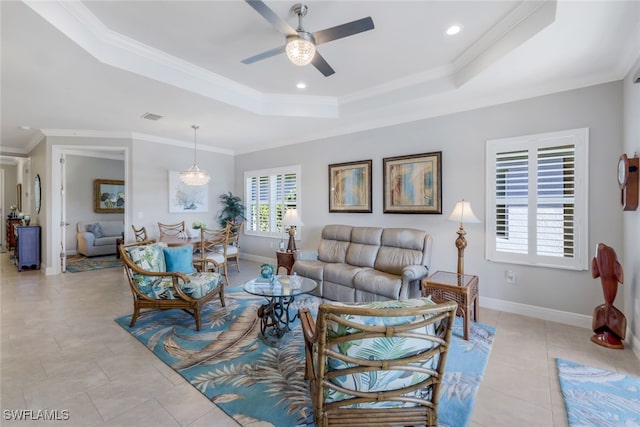 tiled living room with a raised ceiling, ceiling fan, and ornamental molding