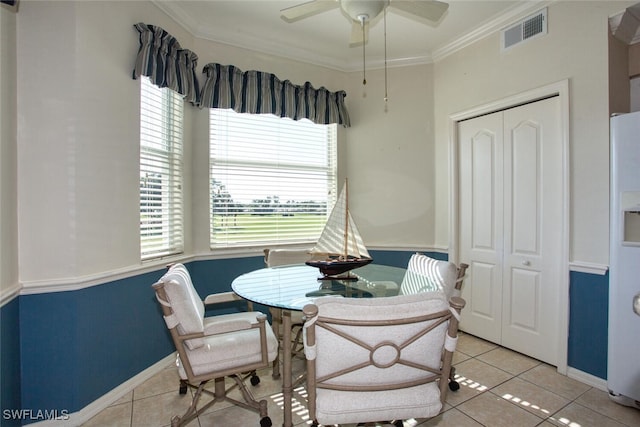 dining area with crown molding, light tile patterned floors, and ceiling fan