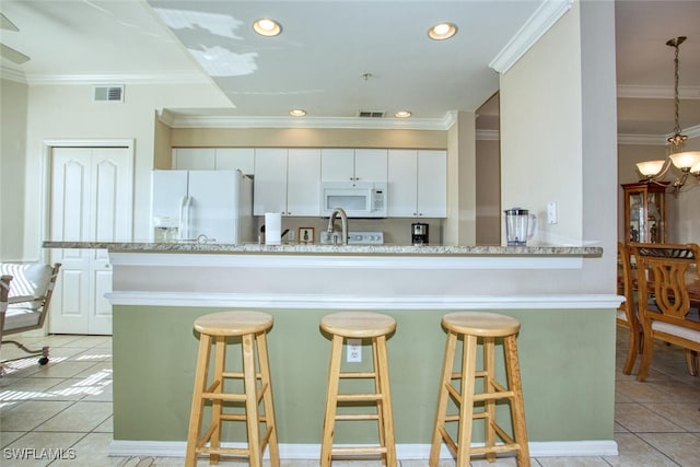 kitchen with a kitchen breakfast bar, white cabinetry, white appliances, and light tile patterned floors